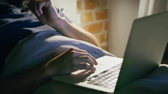 Video man lying in bed and working at night.  Shot with RED helium camera in 8K. alt