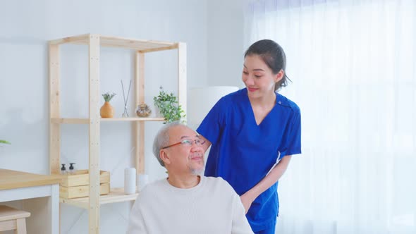 Portrait of Asian caregiver nurse take care senior male on wheelchair. alt