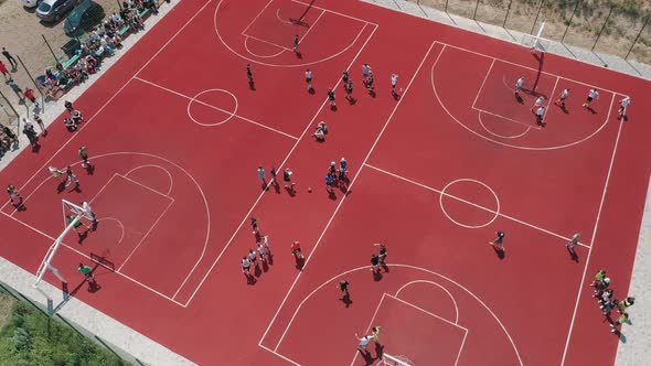 Aerial View of Young Athletes Playing Basketball on an Outdoor Public Basketball Court alt