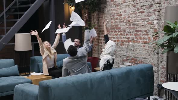 Coworkers Throwing Up a Lot of Financial Documents with Charts and Celebrating Victory alt