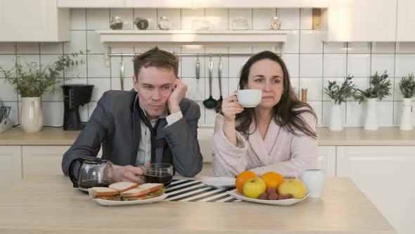 Exhausted Couple Drink Coffee in Morning at Home alt