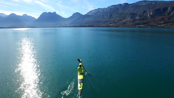 A kayaker paddles in a scenic mountain lake. alt