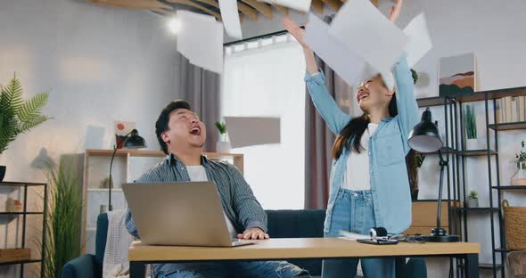 Chinese Couple Celebrating Business Triumph After Getting Good News on Laptop and Giving High Five alt