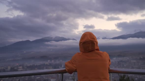 Back View of Man Watching Heavenly View of Razlog City and Misty Mountains alt