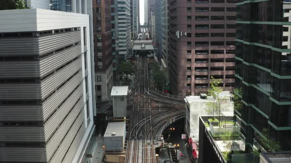 Camera Fly Above Street Between Modern High Rise Buildings Over a Railroad