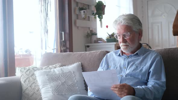 Sad elderly man reading health insurance deal closing looking and reading the medical results alt