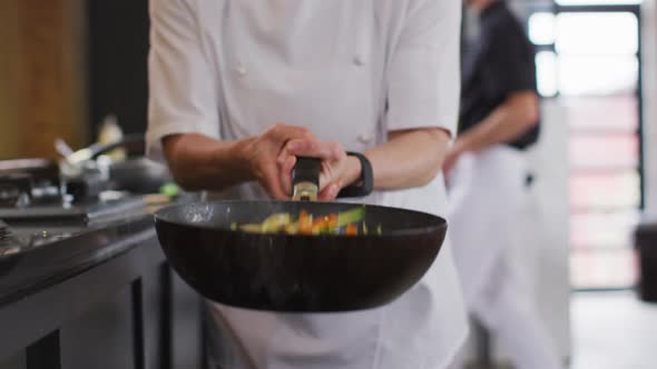 Caucasian female chef teaching diverse group preparing dishes and smiling alt