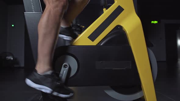 Man Training on a Spin Bike Performs Aerobic Endurance Training on the Simulators in the Gym Cycle alt