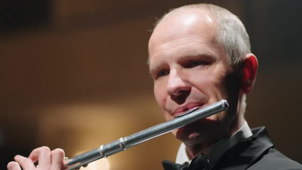 Portrait of Aged Flutist in Opera House Closeup View of Male Face with Flute Classic Music Concert alt