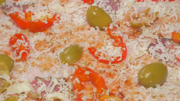 Olives ham and cheese on tasty pizza base with spices 4K 2160p UHD video - Preparing pizza base whil alt