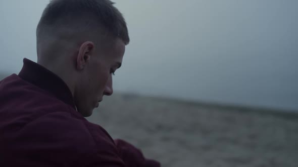 Sad Man Sitting Sandy Beach in Morning alt