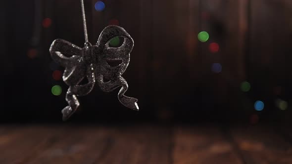 Christmas Tree Silver Toy on a Wooden Background with Flashing Colored Lights alt