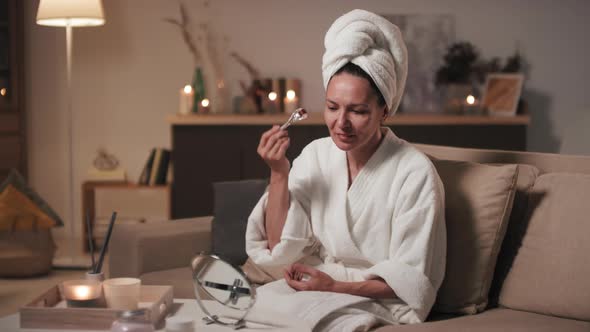 Woman Applying Ice Cube To Face alt