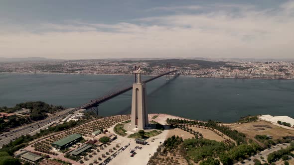 Panoramic aerial wide shot of pedestal monument of Christ the King overlooking at Lisbon city. alt
