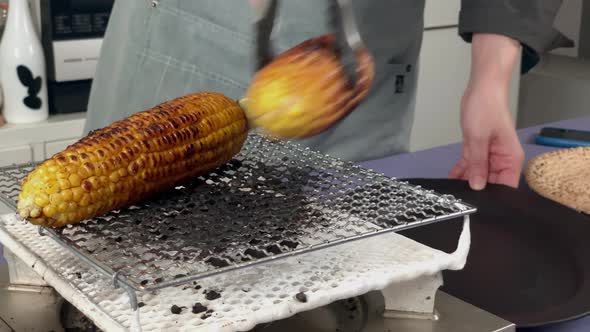 a Japanese female chef removes corn from the heat at her home kitchen, Tokyo, Japan. July 2019. Came alt