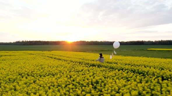 Woman Walking Through Yellow Field During Sunset