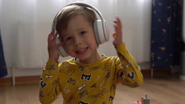 Close Up Handsome Smiling Boy Listening to Music Headphones Indoor