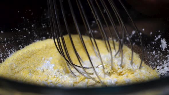 Mixing dry cornmeal and cornstarch ingredients with whisk, Slow Motion Close Up alt