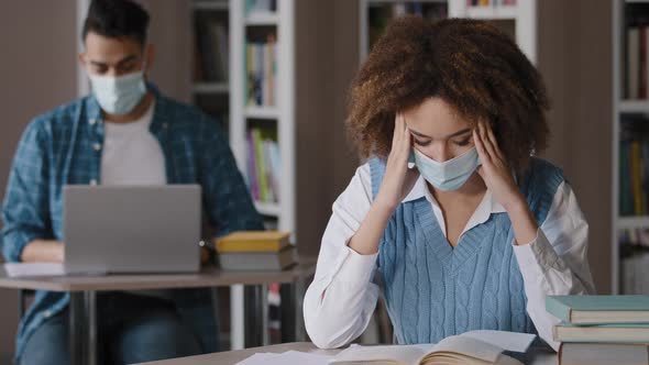 Students Study in Library Young Focused Woman in Medical Mask Sitting at Desk Tired Girl Reading alt