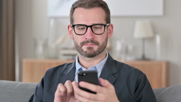 Portrait of Attractive Young Businessman Using Smartphone alt