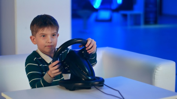 Concentrated Little Boy Playing Virtual Reality Racing Game