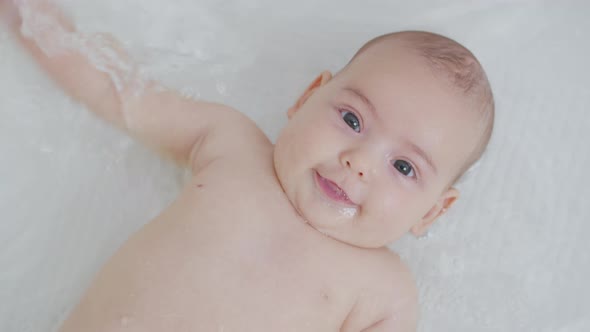 A Baby Girl Bathes in a Bath with a Toy. Closeup. The Concept of Care and Hygiene Over Children, Stock Footage