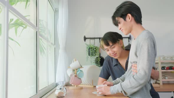 Asian man gay family standing on counter, drink coffee for breakfast. Homosexual-LGBTQ concept. alt