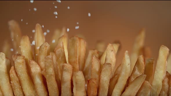 Super Slow Motion Detail Shot of Adding Salt on Fresh French Fries at 1000Fps alt