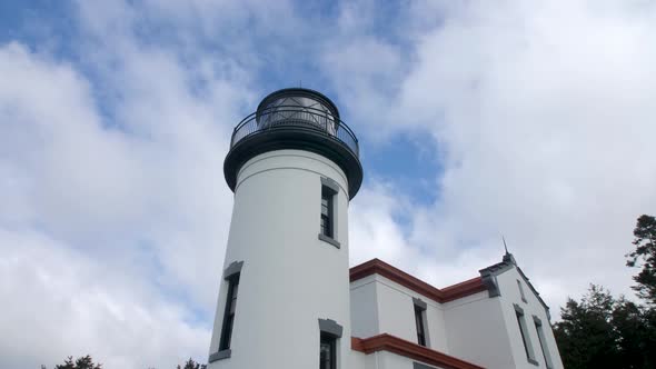 Slow motion orbit looking up at a restored lighthouse at Fort Casey in Washington State. alt