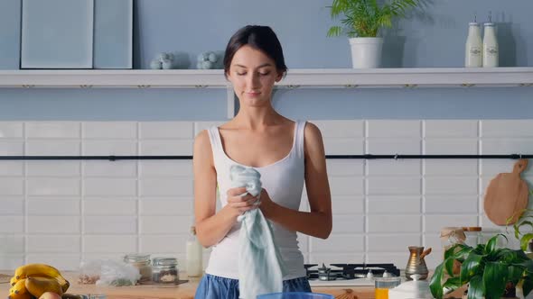 Girl Wipes Her Hands With A Towel While Cooking In The Kitchen