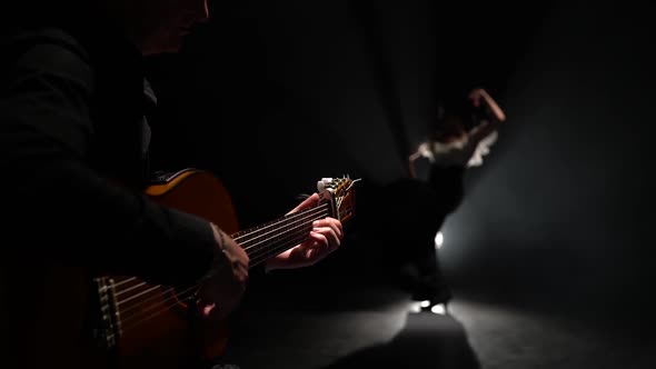 Man on the Guitar Plays a Flamenco Girl Dancing. Light From Behind. Smoke Black Background alt