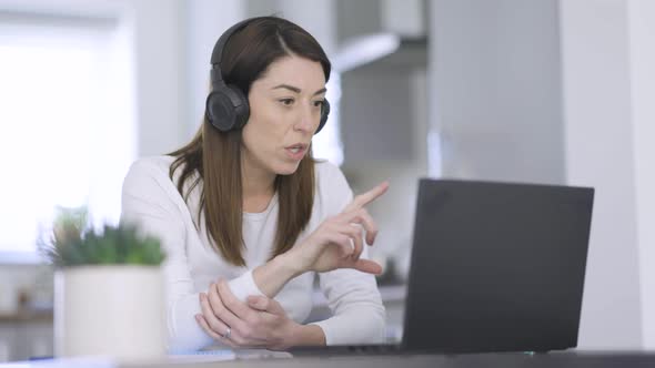 Woman with headphones making video call from home