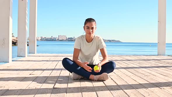 Young  woman sits and plays with ball