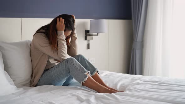 Lonely young woman feeling depressed and stressed sitting in the bedroom alt