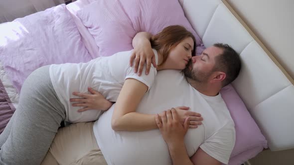 Pregnant Woman and a Man in White T-shirts Lying alt