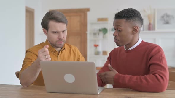 African Man and Young Man Discussing Work on Laptop alt