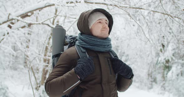 Portrait Happy Male Traveler Backpacker Standing in Winter Forest Smiling and Looking Around alt