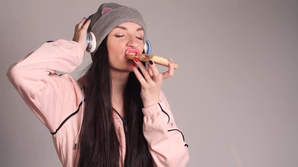 Young Caucasian Woman with Tail Eating Piece of Pizza