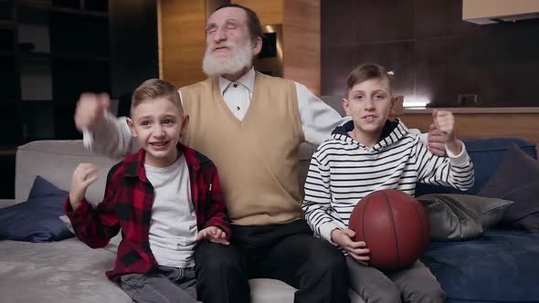 Boys and Their Retired Bearded Grandfather which Watching Sport Game on TV alt