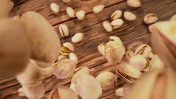 Super Slow Motion Shot of Fresh Roasted Pistachio Nuts Falling on Wooden Table at 1000 Fps alt