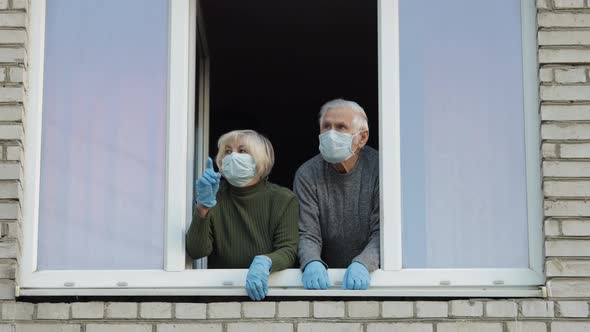 Old Grandparents Stay at Window Isolated at Home on Quarantine. Coronavirus alt