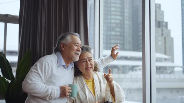 Asian  mature senior couple using tablet and spending time together in living room at home.