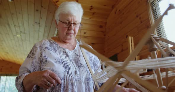 Senior woman operating weaving machine 4K 4k alt