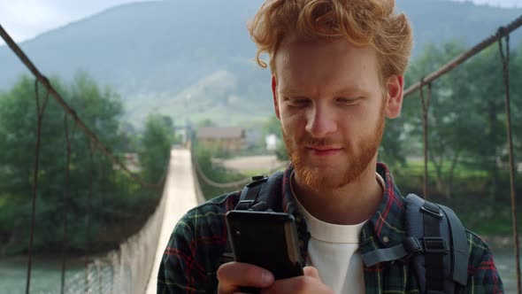 Hitchhiker Texting Mobile Phone at Mountains alt