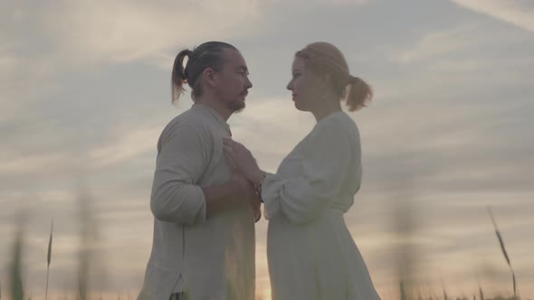 A Heterosexual Slavic Couple Stands in a Wheat Field Looking at Each Other