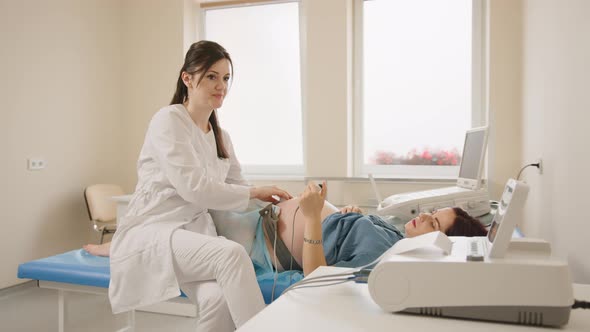 Caucasian Woman Lying on Medical Couch with Belts on Her Pregnant Belly During alt