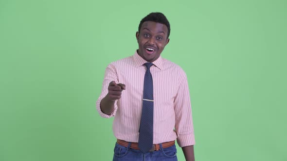 Happy Young African Businessman Pointing To Camera and Giving Thumbs Up