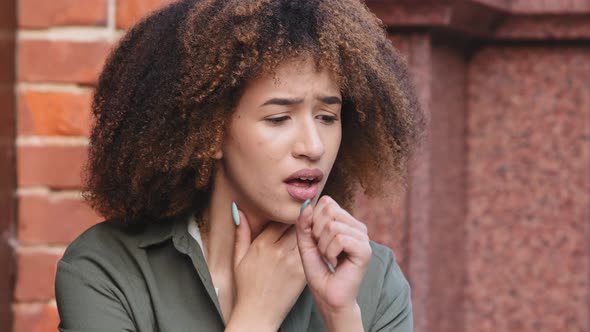 Closeup African American Black Woman Feels Unhealthy and Coughing Touches Neck Suffers From Pain in alt