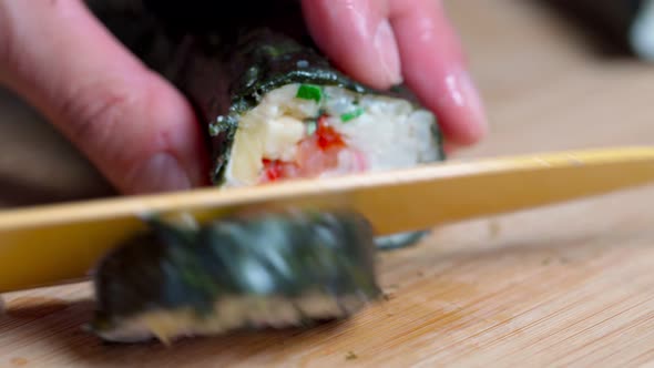 The Chef Cuts Sushi and Rolls Made From Seafood with Asian Ingredients with a Knife alt