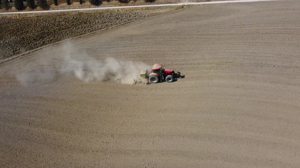 Tractor Plowing Ground for Wheat in Agriculture Rural Field, Pienza Tuscany alt